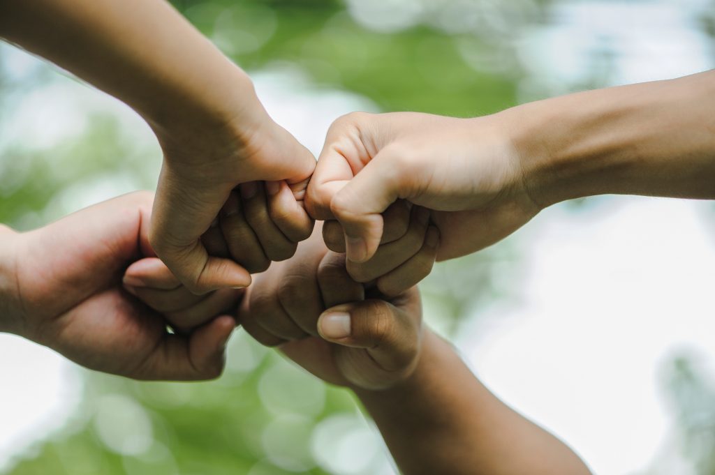 Four fists bumping each other